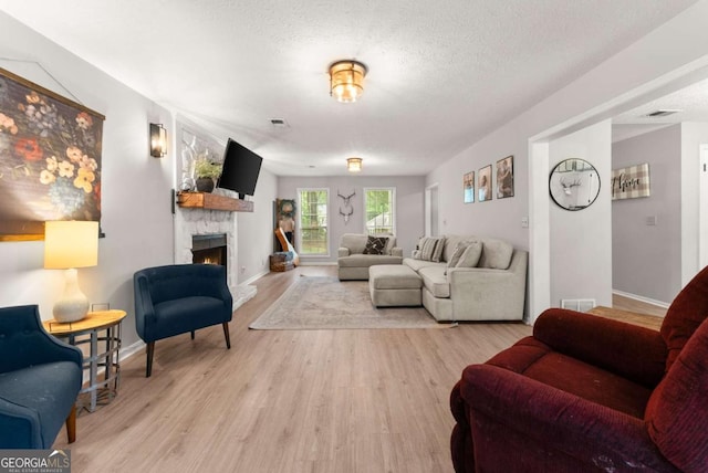 239 Hidden Ct, Winder, GA 30680 - living room featuring wood finished floors, a fireplace, baseboards, and a textured ceiling