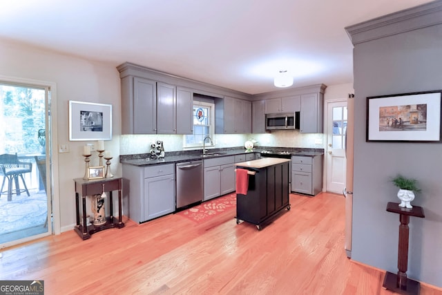 3320 Bryant Ln, Marietta, GA 30066 - kitchen with stainless steel appliances, gray cabinetry, light wood-type flooring, and decorative backsplash