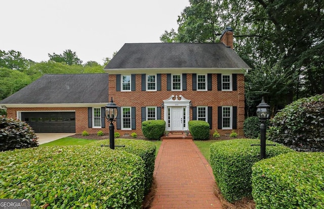 1111 Creekshore Dr, Athens, GA 30606 - colonial home featuring a garage, a chimney, brick siding, and concrete driveway