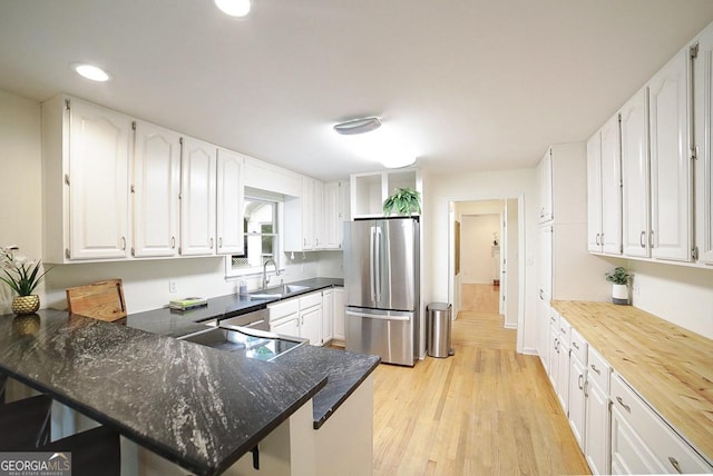 1111 Creekshore Dr, Athens, GA 30606 - kitchen featuring freestanding refrigerator, a sink, a peninsula, white cabinetry, and recessed lighting