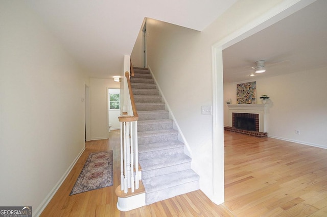 1111 Creekshore Dr, Athens, GA 30606 - stairs featuring ceiling fan, wood finished floors, a fireplace, and baseboards