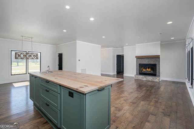 114 Cartecay River Run, Ellijay, GA 30536 - kitchen featuring green cabinetry, butcher block countertops, recessed lighting, a glass covered fireplace, and a kitchen island with sink