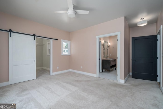 114 Cartecay River Run, Ellijay, GA 30536 - unfurnished bedroom featuring light colored carpet, a barn door, baseboards, and a walk in closet