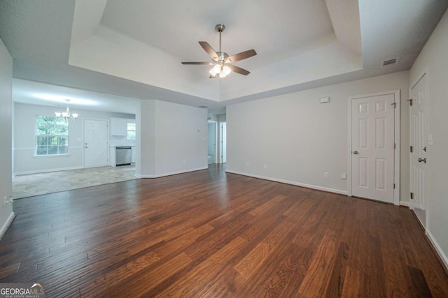 40 Heather Woods Ct, Covington, GA 30016 - unfurnished living room featuring a tray ceiling, ceiling fan, a chandelier, and dark wood finished floors