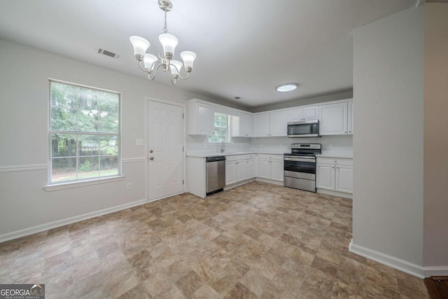 40 Heather Woods Ct, Covington, GA 30016 - kitchen with appliances with stainless steel finishes, white cabinetry, a chandelier, light countertops, and hanging light fixtures