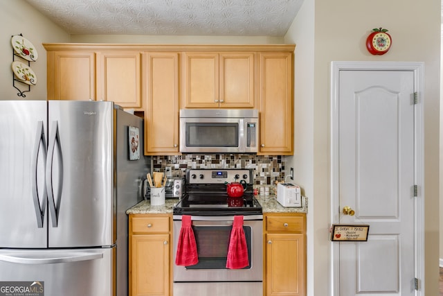 129 Onyx Ct, Carrollton, GA 30116 - kitchen featuring stainless steel appliances, decorative backsplash, light stone counters, and light brown cabinets