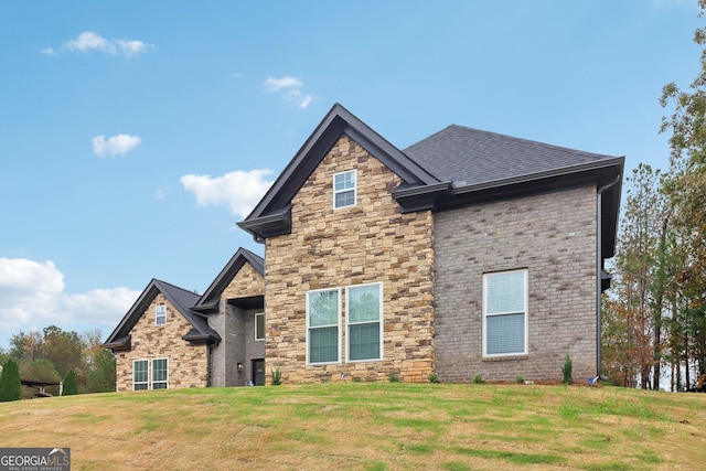 4186 Matisse Ln, Fairburn, GA 30213 - view of front facade with a front yard, a shingled roof, stone siding, and brick siding