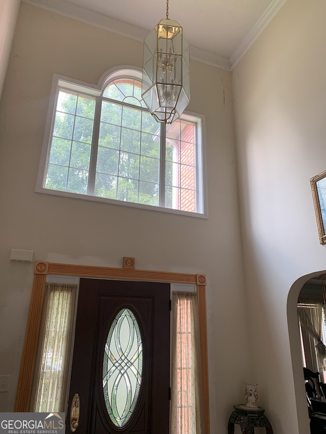 6570 Laurens Way, Stone Mountain, GA 30087 - foyer entrance with arched walkways, a chandelier, healthy amount of natural light, a high ceiling, and ornamental molding