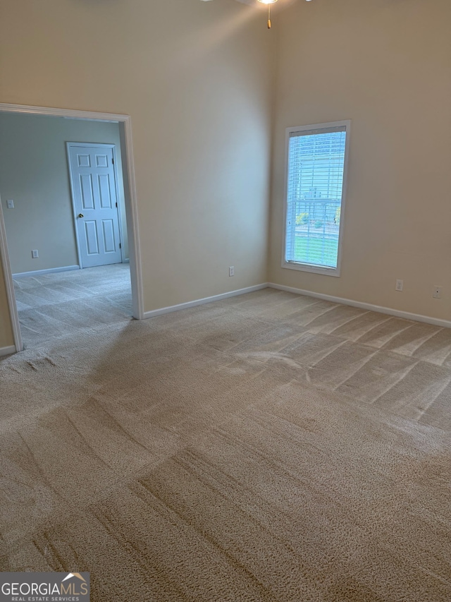 1925 Cedar Walk Ln, Conley, GA 30288 - empty room with light colored carpet, baseboards, a high ceiling, and a ceiling fan
