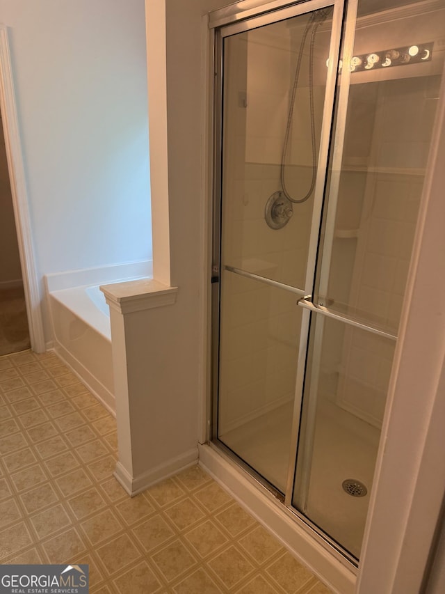 1925 Cedar Walk Ln, Conley, GA 30288 - full bathroom featuring a stall shower, a bath, tile patterned floors, and baseboards