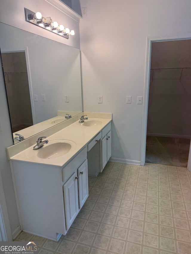 1925 Cedar Walk Ln, Conley, GA 30288 - bathroom featuring double vanity, a walk in closet, baseboards, and tile patterned floors