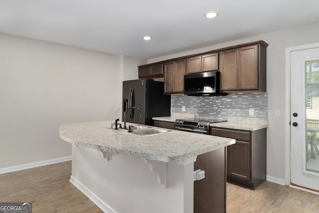 304 Boomer Ct, Guyton, GA 31312 - kitchen with black fridge, a sink, electric stove, baseboards, and recessed lighting