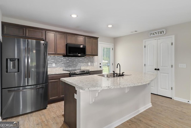 304 Boomer Ct, Guyton, GA 31312 - kitchen featuring stainless steel appliances, a sink, light wood-style floors, dark brown cabinets, and recessed lighting