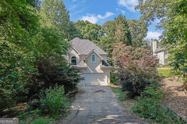 6708 Thornwood Ct, Flowery Branch, GA 30542 - view of property hidden behind natural elements featuring stucco siding, driveway, and an attached garage