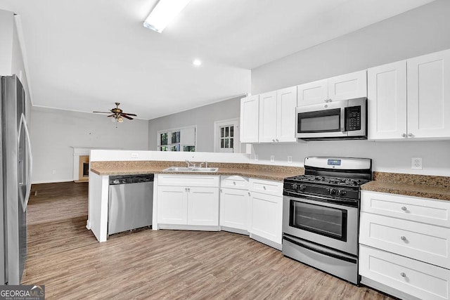 6708 Thornwood Ct, Flowery Branch, GA 30542 - kitchen featuring appliances with stainless steel finishes, white cabinetry, a peninsula, and a sink