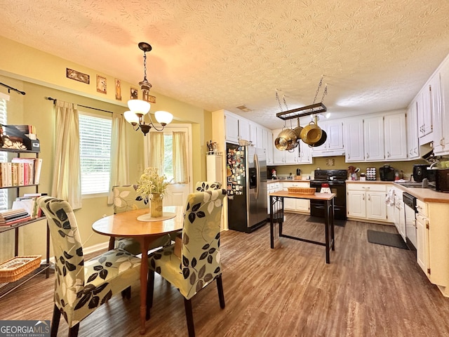 150 Willow Shoals Dr, Covington, GA 30016 - dining area featuring wood finished floors, a textured ceiling, and a chandelier