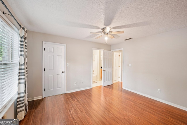 514 Mcgill Pl NE, Atlanta, GA 30312 - unfurnished bedroom featuring wood finished floors, baseboards, a textured ceiling, a ceiling fan, and ensuite bathroom
