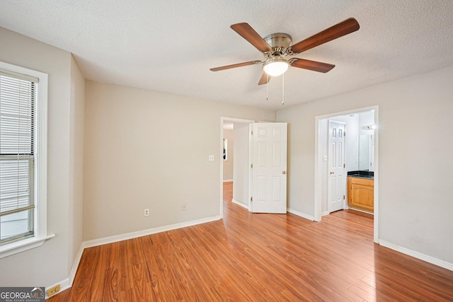 514 Mcgill Pl NE, Atlanta, GA 30312 - unfurnished bedroom with light wood-style flooring, baseboards, a textured ceiling, ensuite bath, and ceiling fan