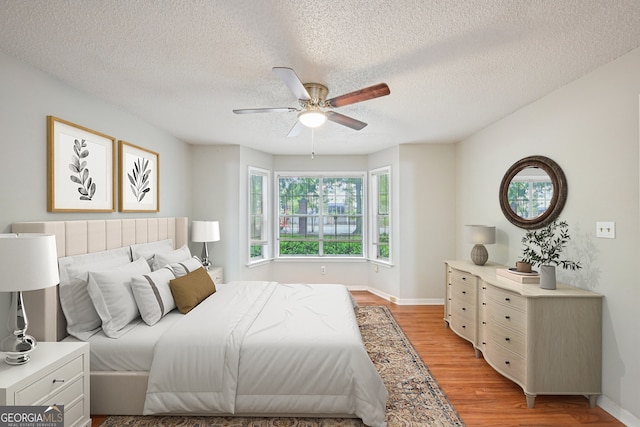 514 Mcgill Pl NE, Atlanta, GA 30312 - bedroom with light wood-type flooring, a textured ceiling, a ceiling fan, and baseboards