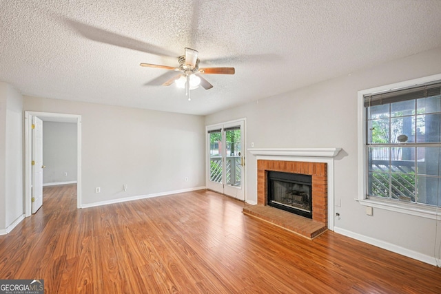 514 Mcgill Pl NE, Atlanta, GA 30312 - unfurnished living room featuring a ceiling fan, wood finished floors, a fireplace, a textured ceiling, and baseboards