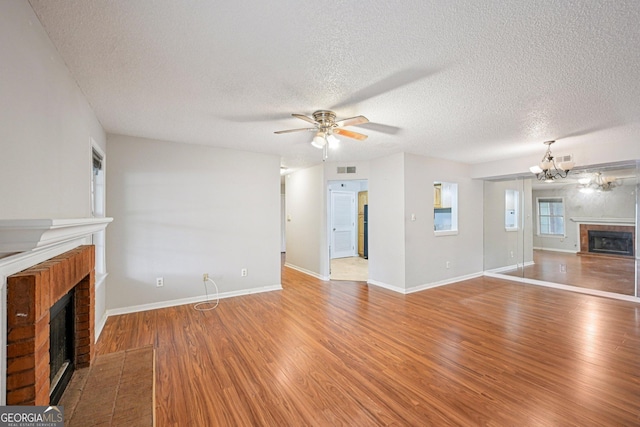514 Mcgill Pl NE, Atlanta, GA 30312 - unfurnished living room with a fireplace, wood finished floors, ceiling fan, a textured ceiling, and a chandelier