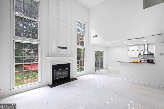 984 Wenham Ln, Lawrenceville, GA 30044 - unfurnished living room with marble tiled flooring, a high ceiling, a large fireplace, and plenty of natural light
