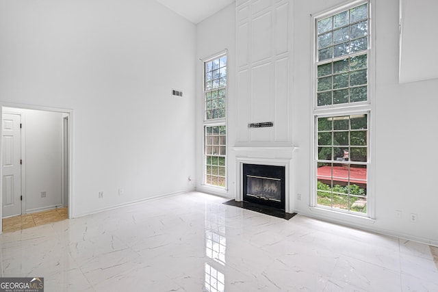 984 Wenham Ln, Lawrenceville, GA 30044 - unfurnished living room with a towering ceiling, marble finish floors, baseboards, and a fireplace