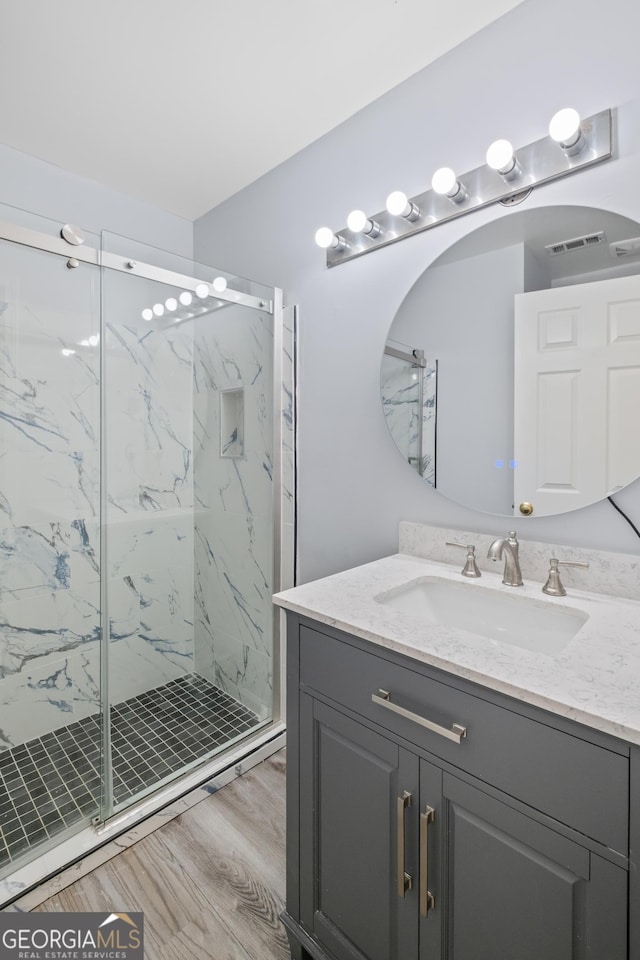 984 Wenham Ln, Lawrenceville, GA 30044 - full bath featuring vanity, a marble finish shower, and wood finished floors
