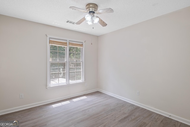 984 Wenham Ln, Lawrenceville, GA 30044 - unfurnished room with wood finished floors, a ceiling fan, baseboards, and a textured ceiling