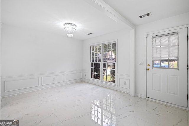 984 Wenham Ln, Lawrenceville, GA 30044 - foyer with light marble finish flooring, a decorative wall, and a wainscoted wall