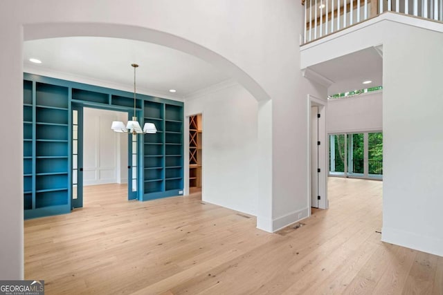 615 Claxton Ln, Milton, GA 30004 - spare room with arched walkways, wood-type flooring, a chandelier, ornamental molding, and built in features
