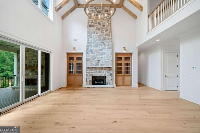 615 Claxton Ln, Milton, GA 30004 - unfurnished living room featuring high vaulted ceiling, beam ceiling, a chandelier, wood finished floors, and a stone fireplace