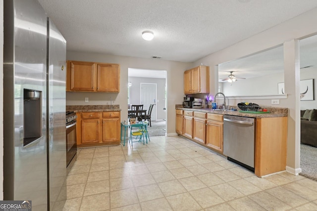 7813 Newbury Dr, Jonesboro, GA 30236 - kitchen featuring appliances with stainless steel finishes, a textured ceiling, ceiling fan, a sink, and baseboards
