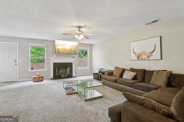 7813 Newbury Dr, Jonesboro, GA 30236 - living room with plenty of natural light, carpet flooring, ceiling fan, a textured ceiling, and a fireplace with flush hearth