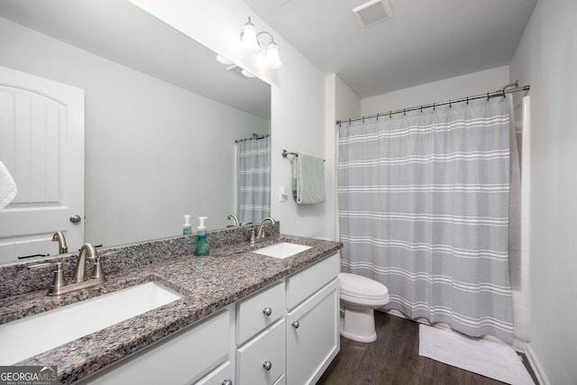 9929 Long Leaf Pine Dr, Midland, GA 31820 - full bathroom with wood finished floors, toilet, double vanity, and a shower with shower curtain