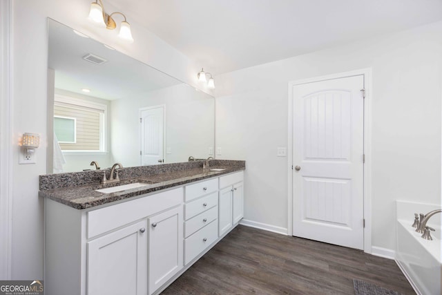 9929 Long Leaf Pine Dr, Midland, GA 31820 - full bath with double vanity, wood finished floors, a bath, and baseboards