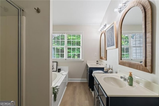 3088 Steeplechase Dr, Alpharetta, GA 30004 - bathroom featuring two vanities, baseboards, a bath, wood finished floors, and a shower