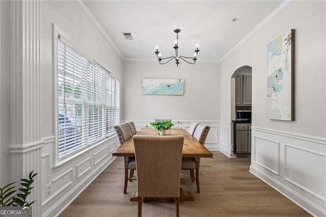 3088 Steeplechase Dr, Alpharetta, GA 30004 - dining room with a chandelier, arched walkways, a decorative wall, ornamental molding, and wood finished floors