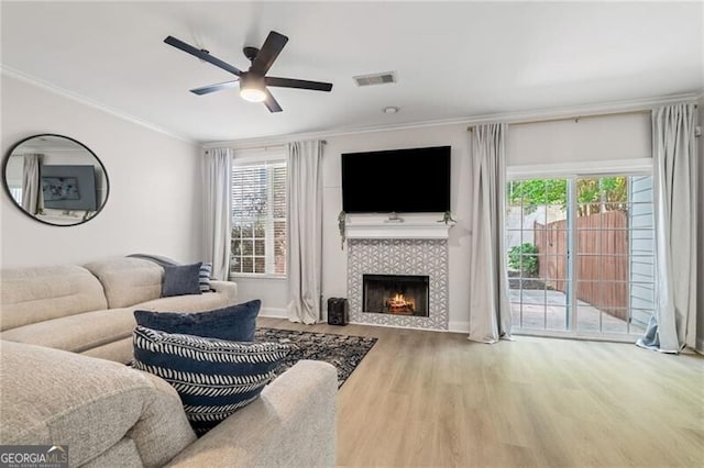 3088 Steeplechase Dr, Alpharetta, GA 30004 - living area featuring wood finished floors, ornamental molding, a ceiling fan, plenty of natural light, and a tiled fireplace