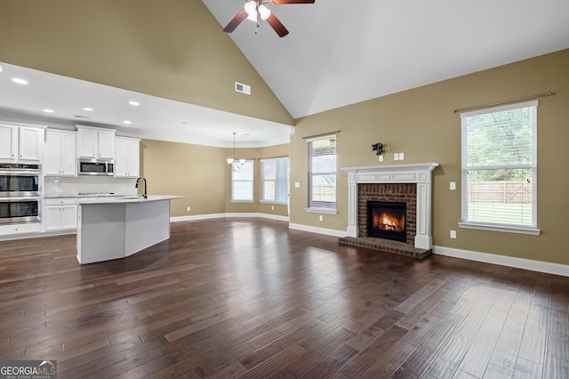 108 Donovan Ave, Locust Grove, GA 30248 - unfurnished living room featuring ceiling fan, a brick fireplace, a sink, baseboards, and high vaulted ceiling