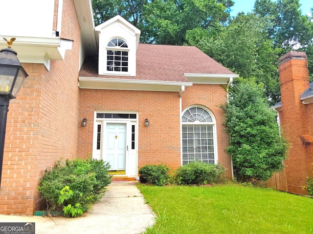 3332 Glenrose Trl, Chamblee, GA 30341 - view of exterior entry with brick siding, a lawn, and a shingled roof