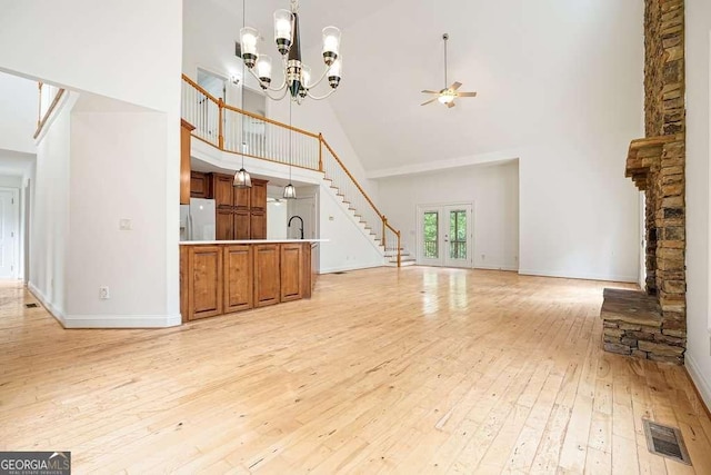326 Seldom Seen Trl, Canton, GA 30115 - unfurnished living room featuring high vaulted ceiling, stairs, light wood-type flooring, ceiling fan, and a chandelier