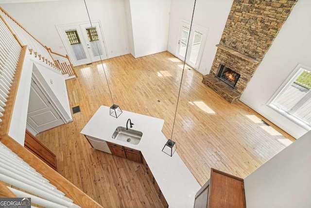 326 Seldom Seen Trl, Canton, GA 30115 - unfurnished living room with a high ceiling, stairway, hardwood / wood-style flooring, french doors, and a stone fireplace