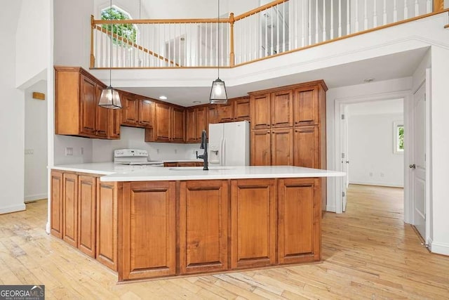 326 Seldom Seen Trl, Canton, GA 30115 - kitchen with a towering ceiling, white appliances, light wood-style flooring, light countertops, and brown cabinets