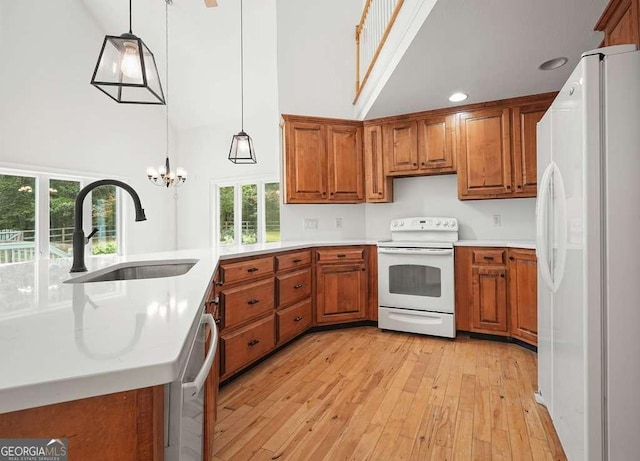 326 Seldom Seen Trl, Canton, GA 30115 - kitchen featuring white appliances, a towering ceiling, brown cabinets, light wood-type flooring, and recessed lighting