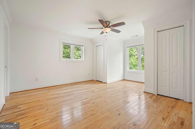 326 Seldom Seen Trl, Canton, GA 30115 - unfurnished bedroom with multiple closets, crown molding, light wood-style floors, and ceiling fan