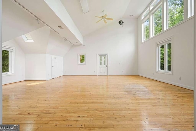 326 Seldom Seen Trl, Canton, GA 30115 - unfurnished living room featuring rail lighting, light wood-style floors, a skylight, and high vaulted ceiling