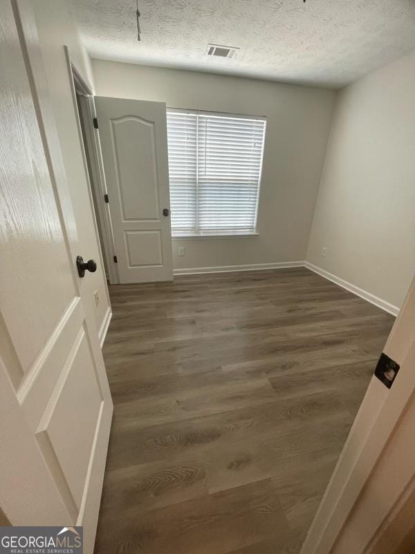 140 Clover Valley Dr, Covington, GA 30016 - spare room featuring wood finished floors, baseboards, and a textured ceiling