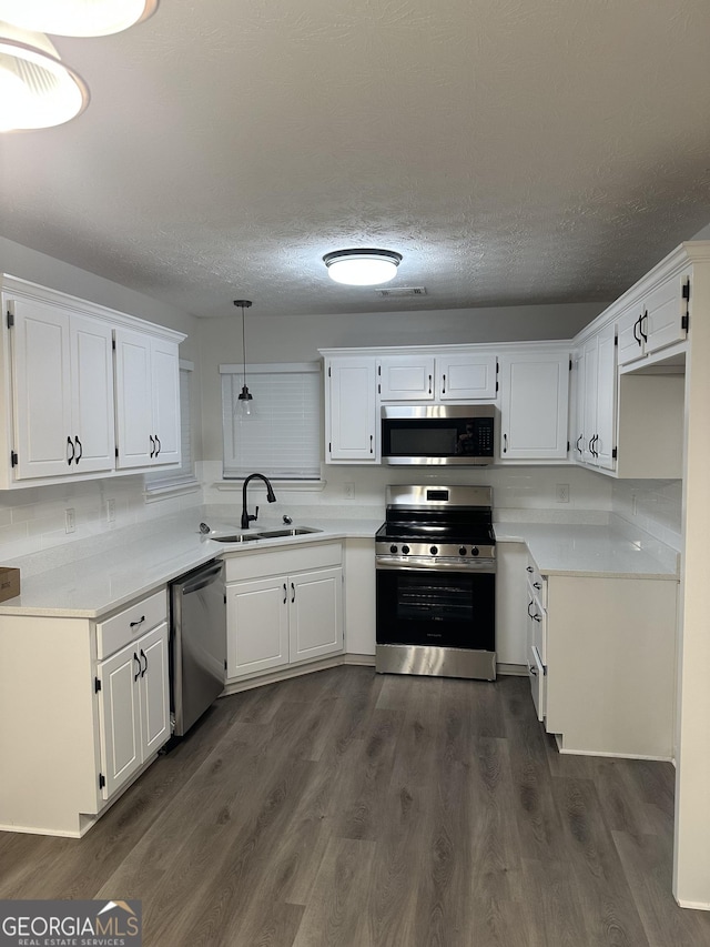 140 Clover Valley Dr, Covington, GA 30016 - kitchen featuring appliances with stainless steel finishes, a sink, white cabinets, and a textured ceiling