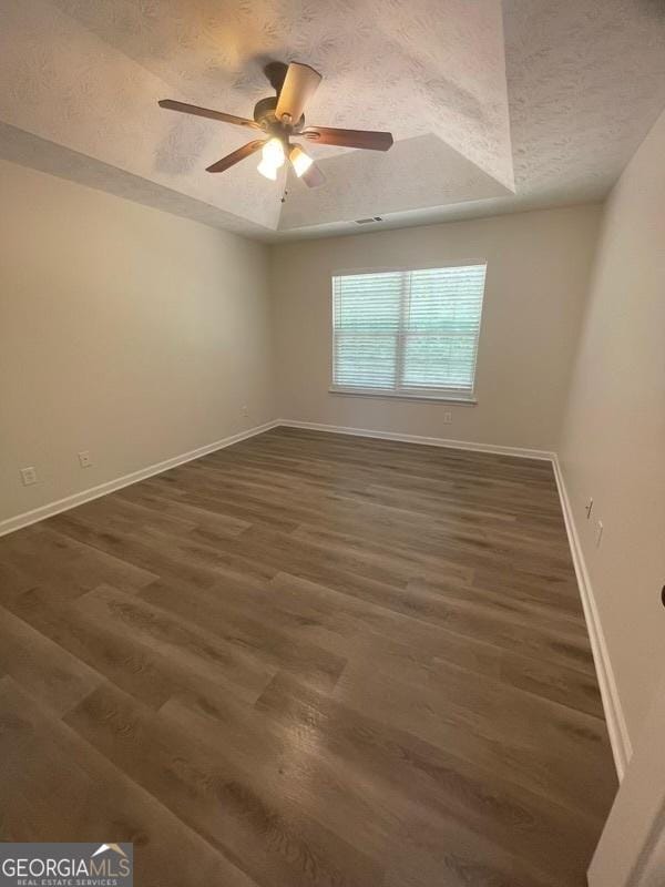 140 Clover Valley Dr, Covington, GA 30016 - spare room with a textured ceiling, dark wood-style floors, baseboards, and a ceiling fan